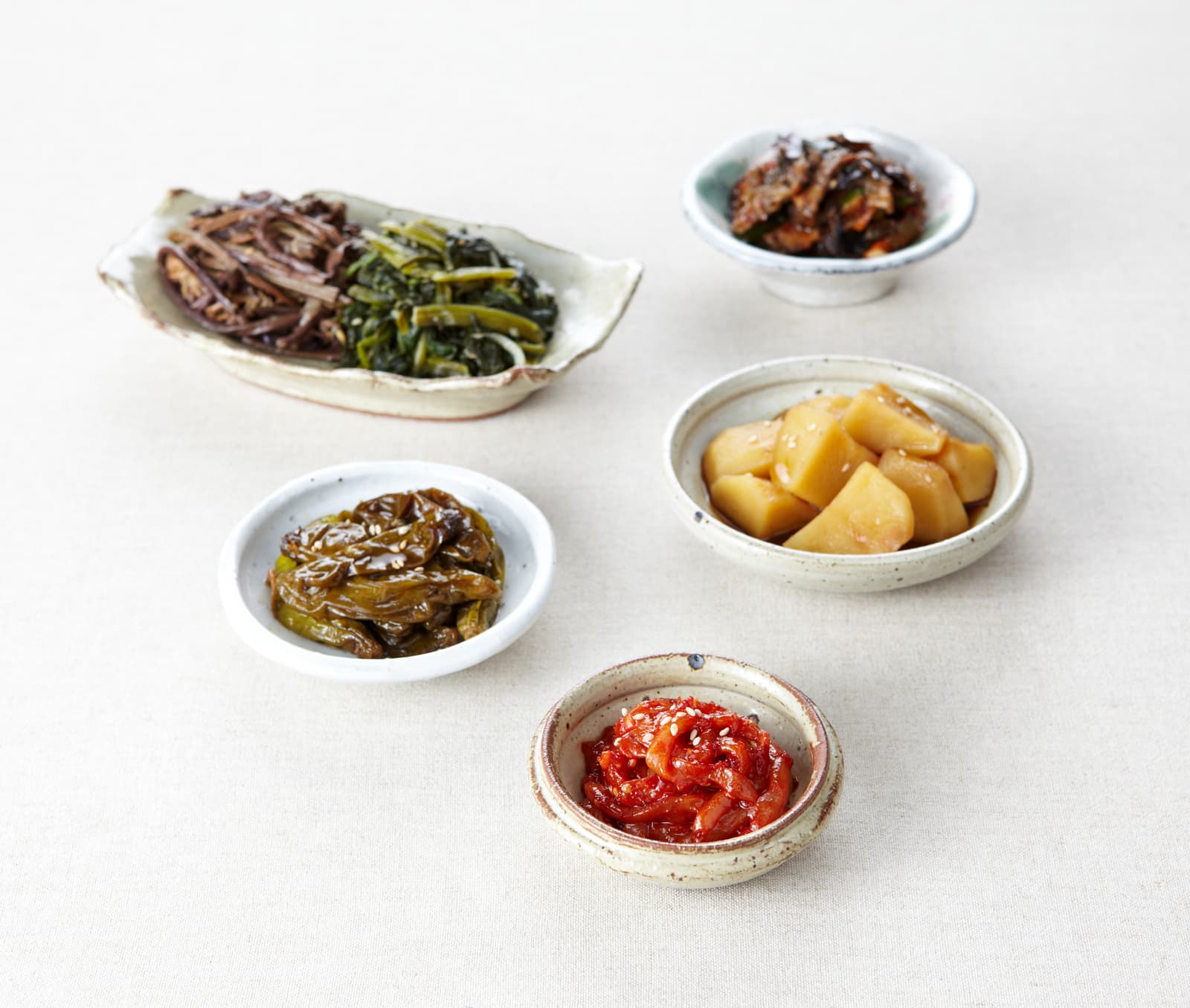 Assortiment de banchan, petits plats d’accompagnement coréens servis dans de multiples bols.
