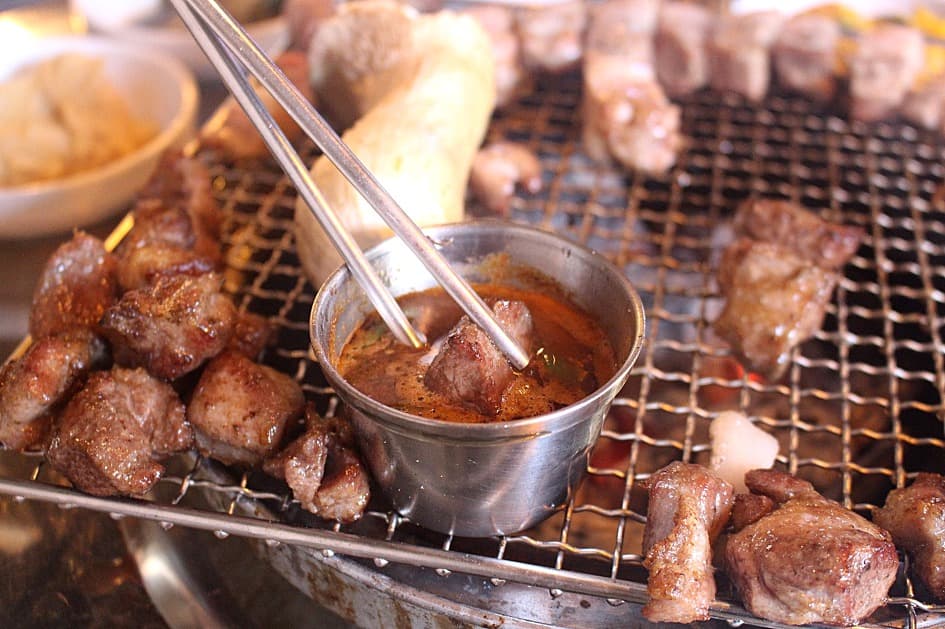 Barbecue coréen (gogigui) avec viande grillée trempée dans une sauce.