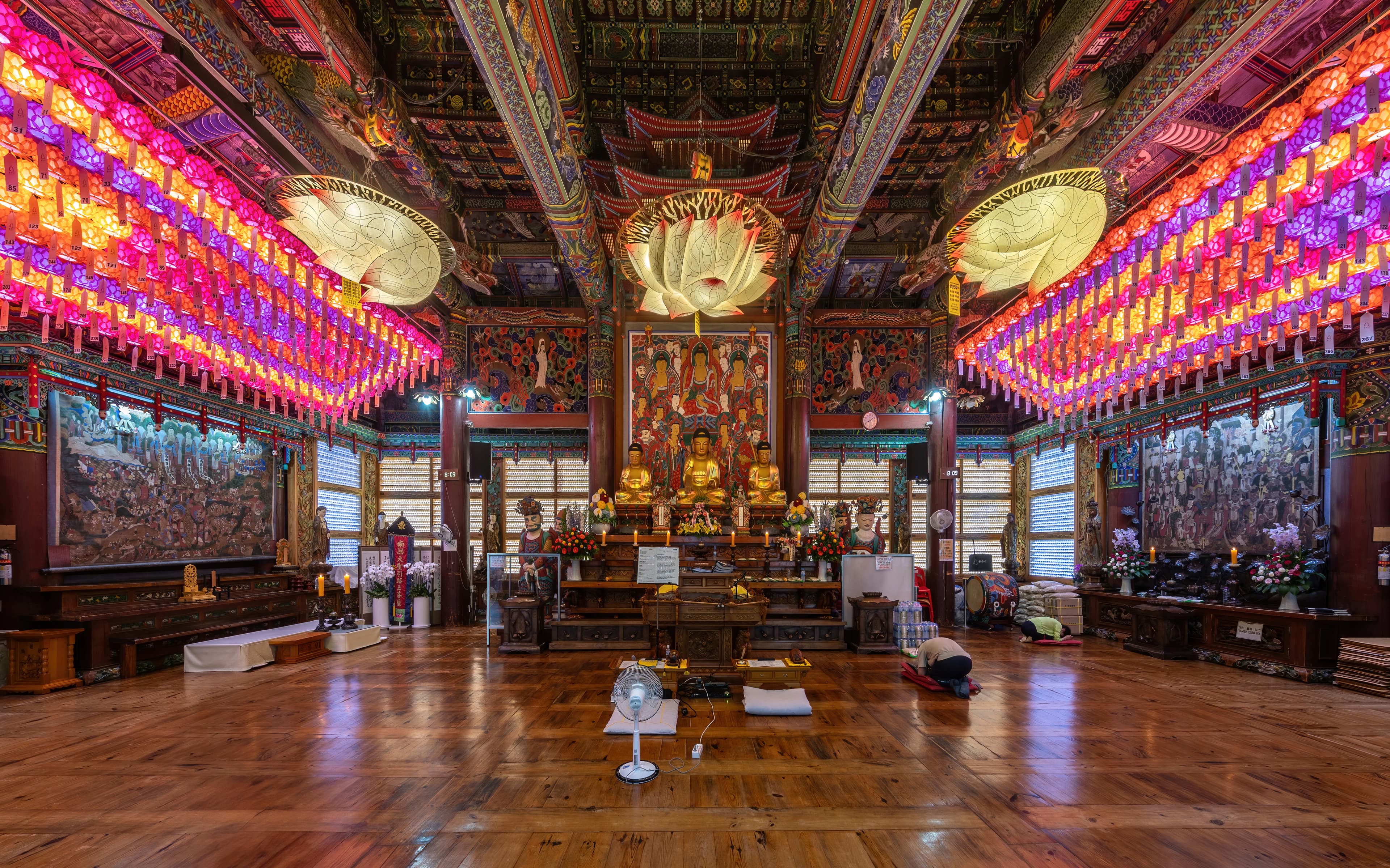 Intérieur richement coloré de la salle principale du temple Bongeunsa à Séoul, aux poutres peintes de vermillon, d'or et de motifs dancheong