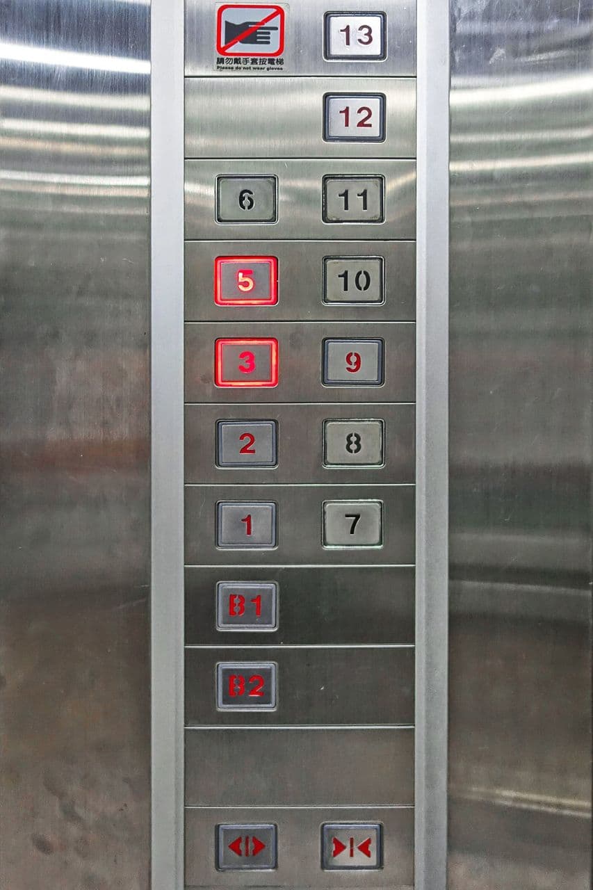 Panneau de commande d'ascenseur où le bouton du quatrième étage est absent, illustration de la tétraphobie.