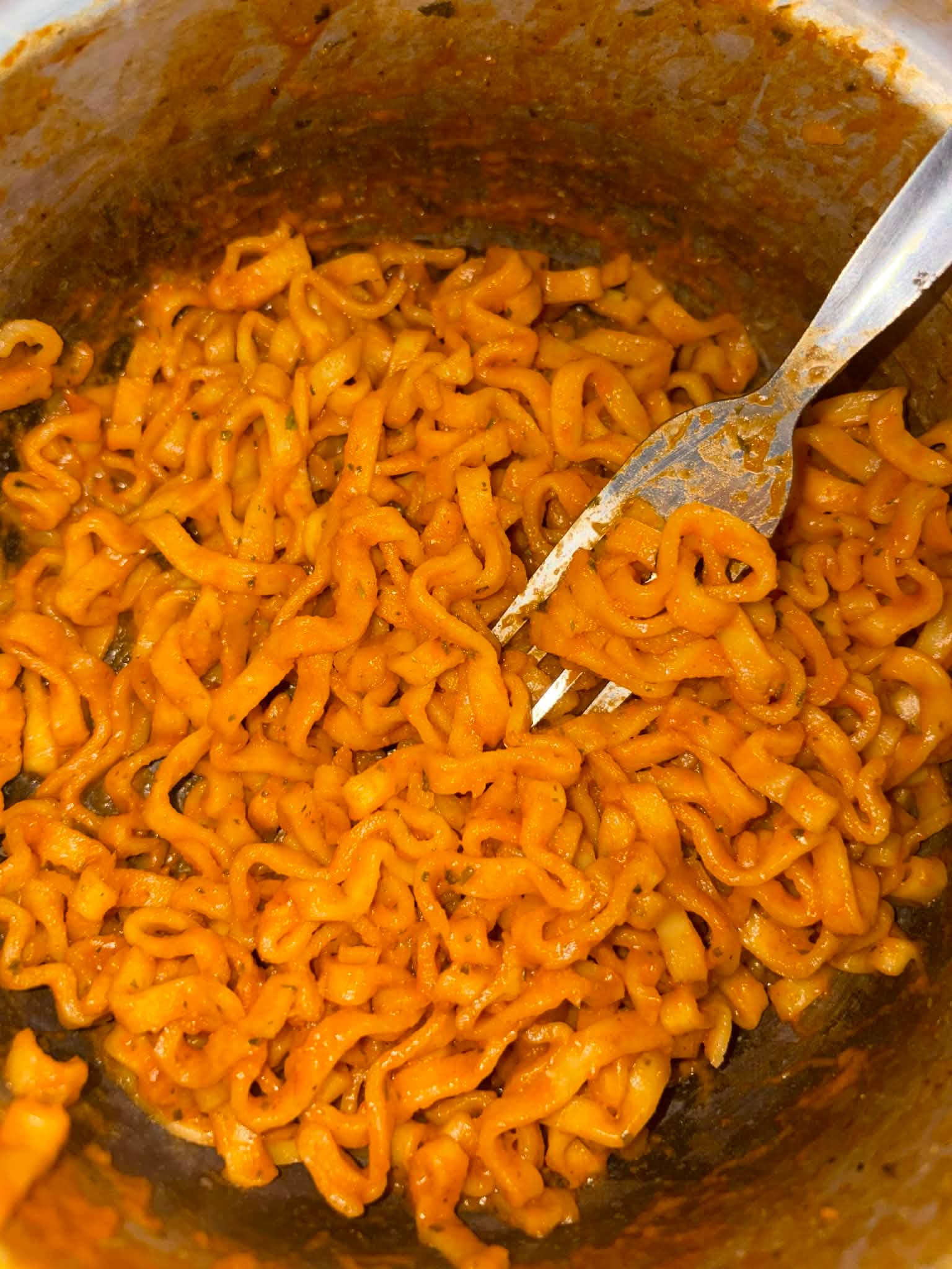 Un bol de ramyeon coreen epice au bouillon rouge, nouilles instantanees garnies