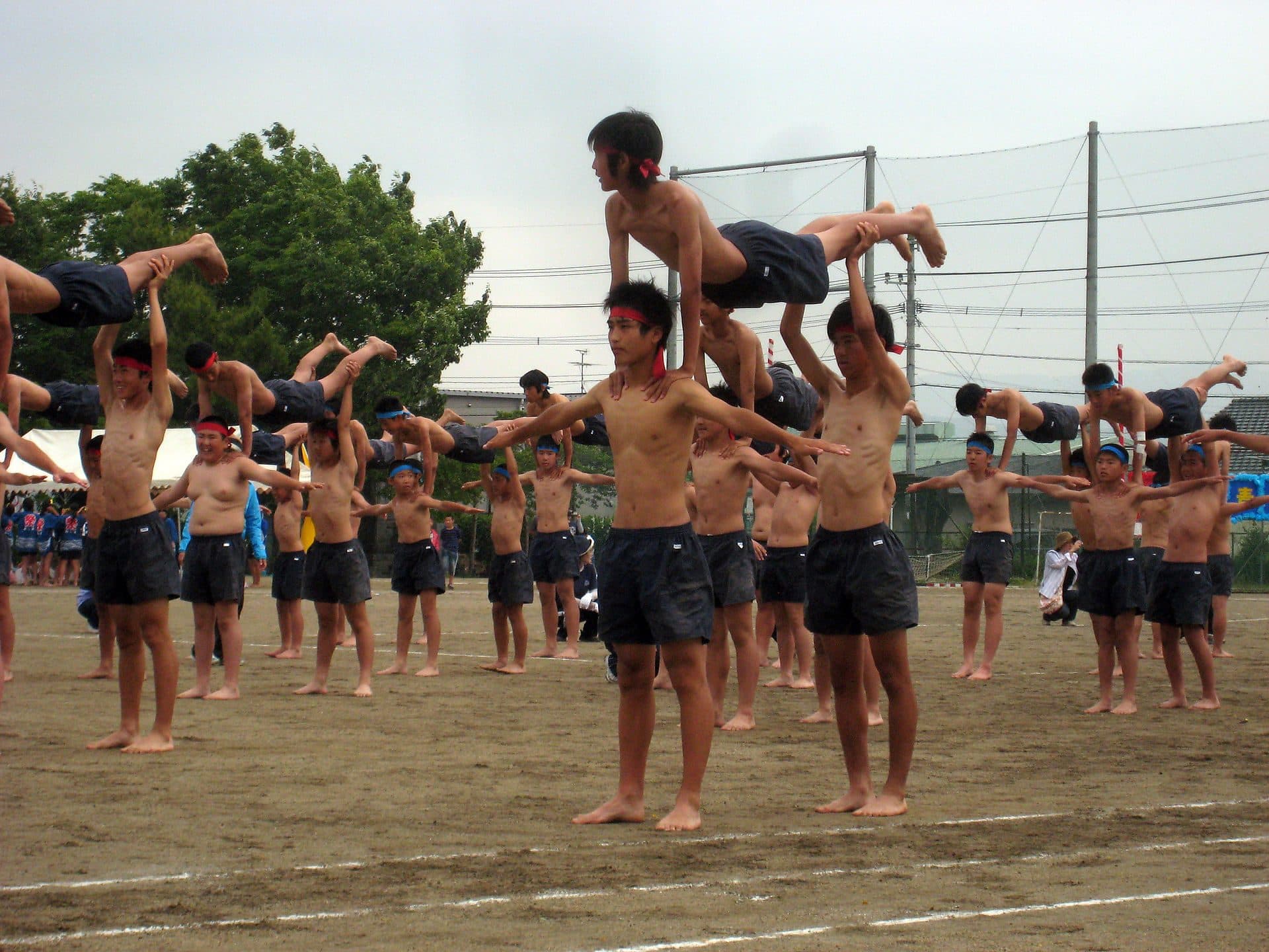 Élèves japonais rassemblés sur la cour de leur établissement pendant la fête sportive scolaire.
