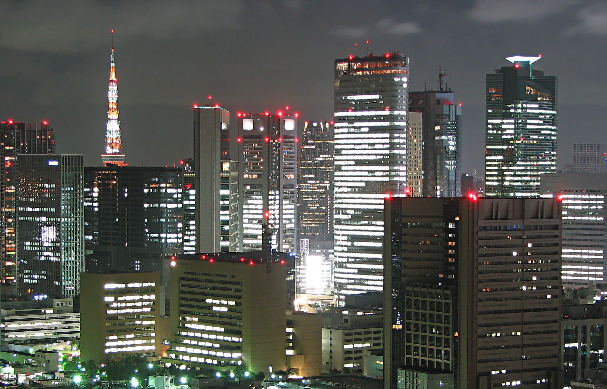 Vue nocturne de Tokyo illuminée, gratte-ciels et néons évoquant l’ambiance urbaine de la city pop.