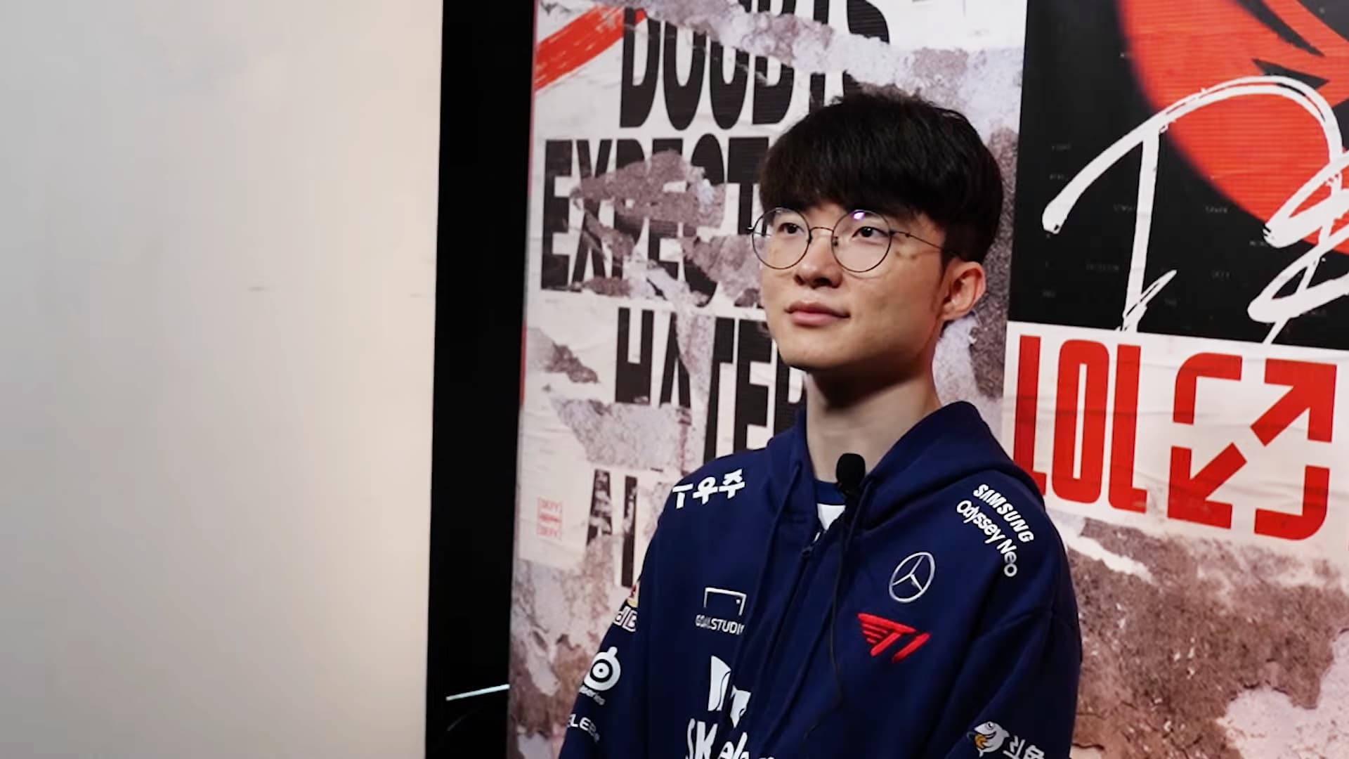 Le joueur coreen Faker en veste d'equipe T1 lors du Mid-Season Invitational 2023, devant un decor aux couleurs de la competition League of Legends