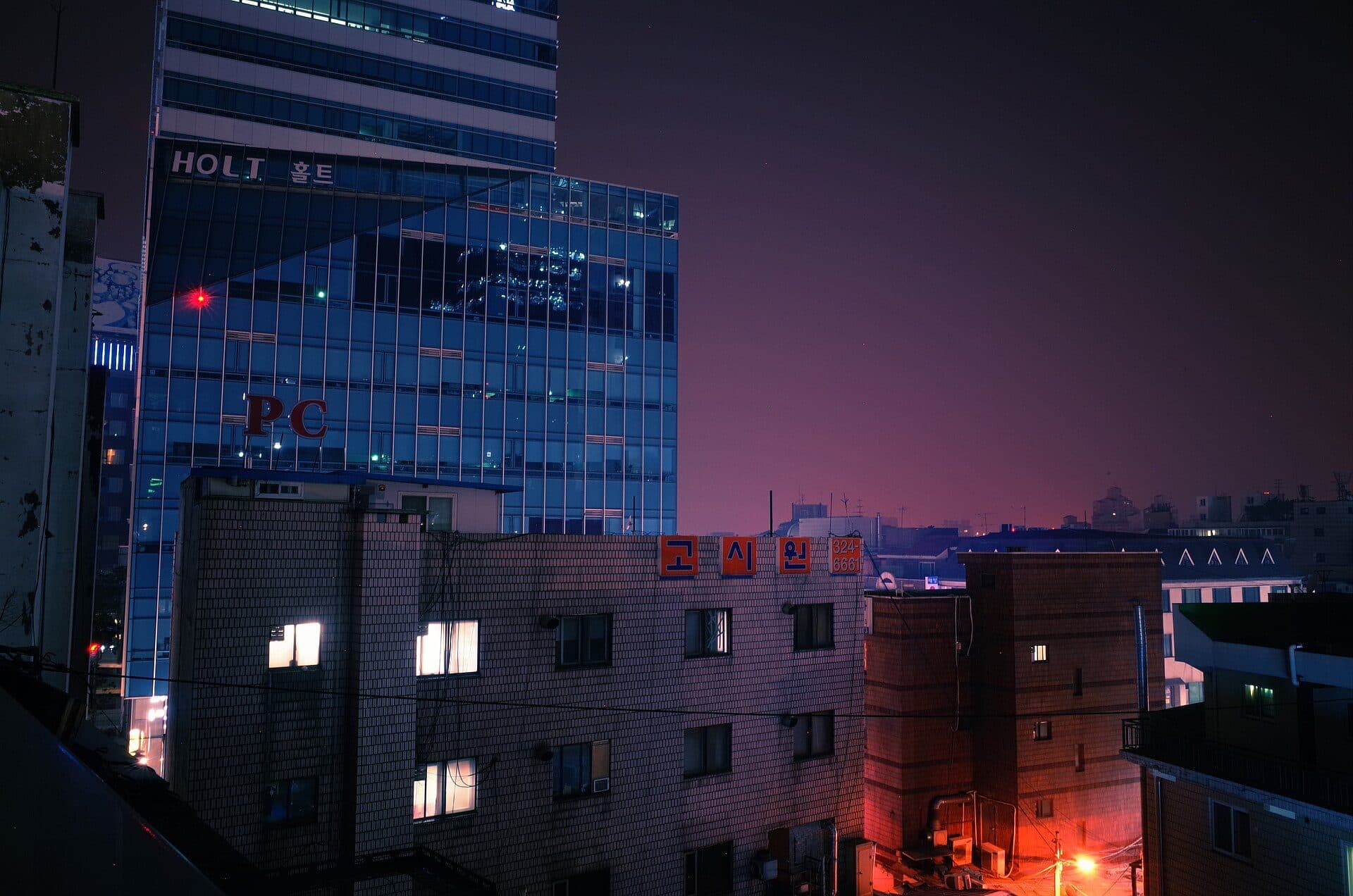 Enseigne d'un gosiwon sur la façade d'un immeuble de Séoul, la nuit.
