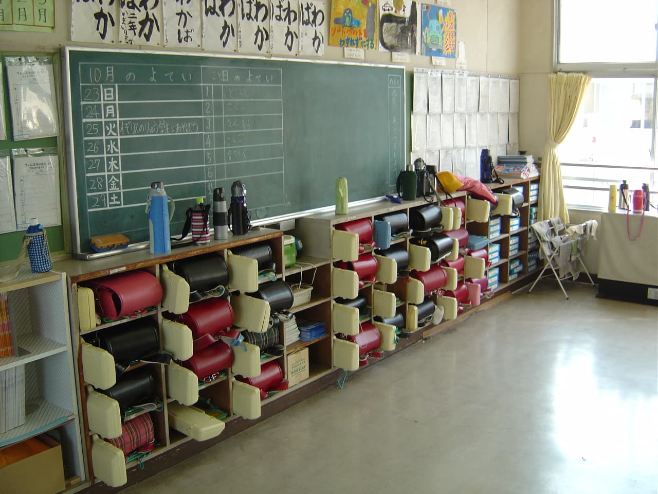 Salle de classe typique d’une école élémentaire japonaise, avec cartables et casiers au fond.