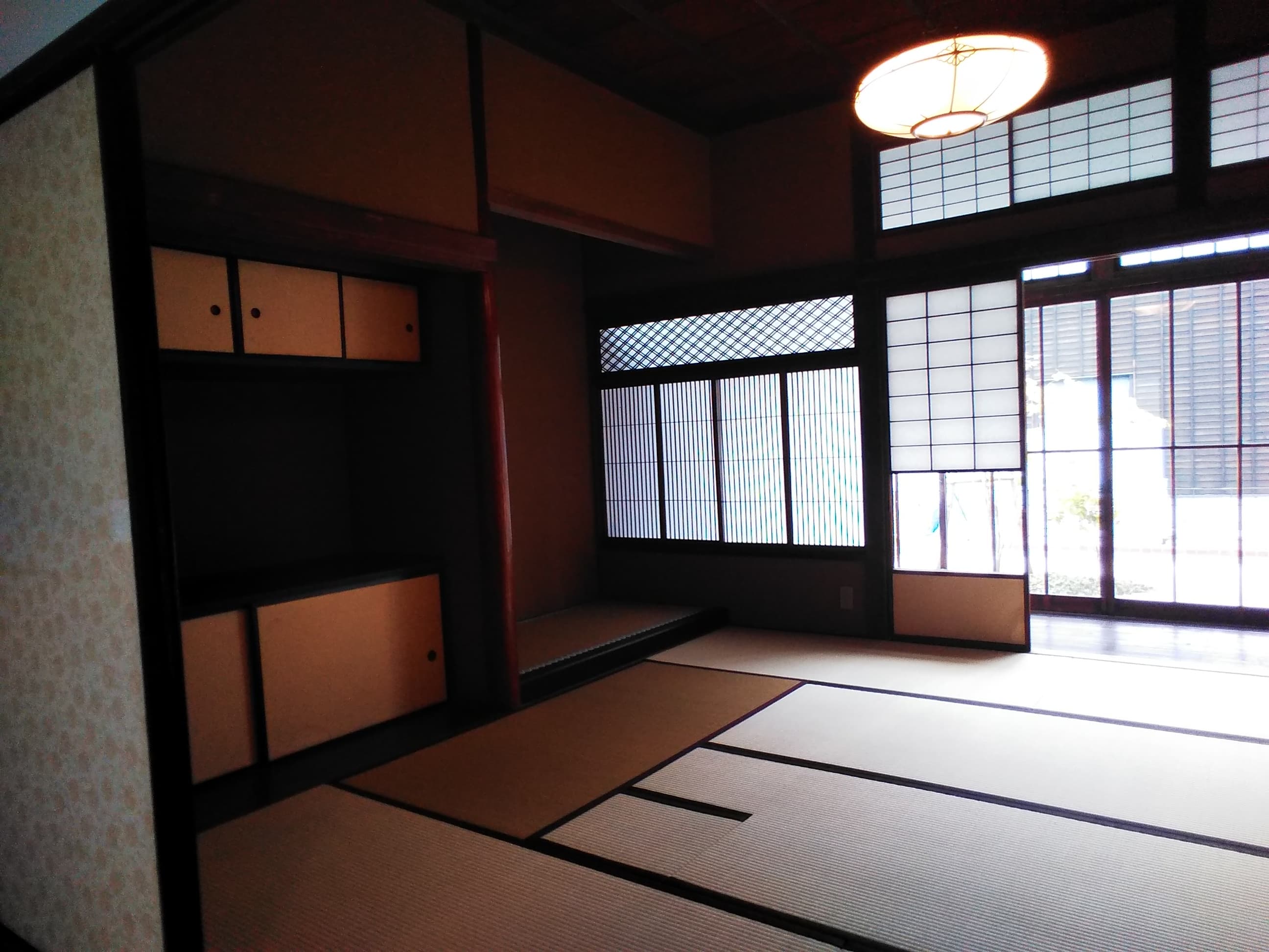 Pièce japonaise traditionnelle en tatamis presque vide, baignée de lumière à travers un shōji, illustrant l’esthétique du vide.