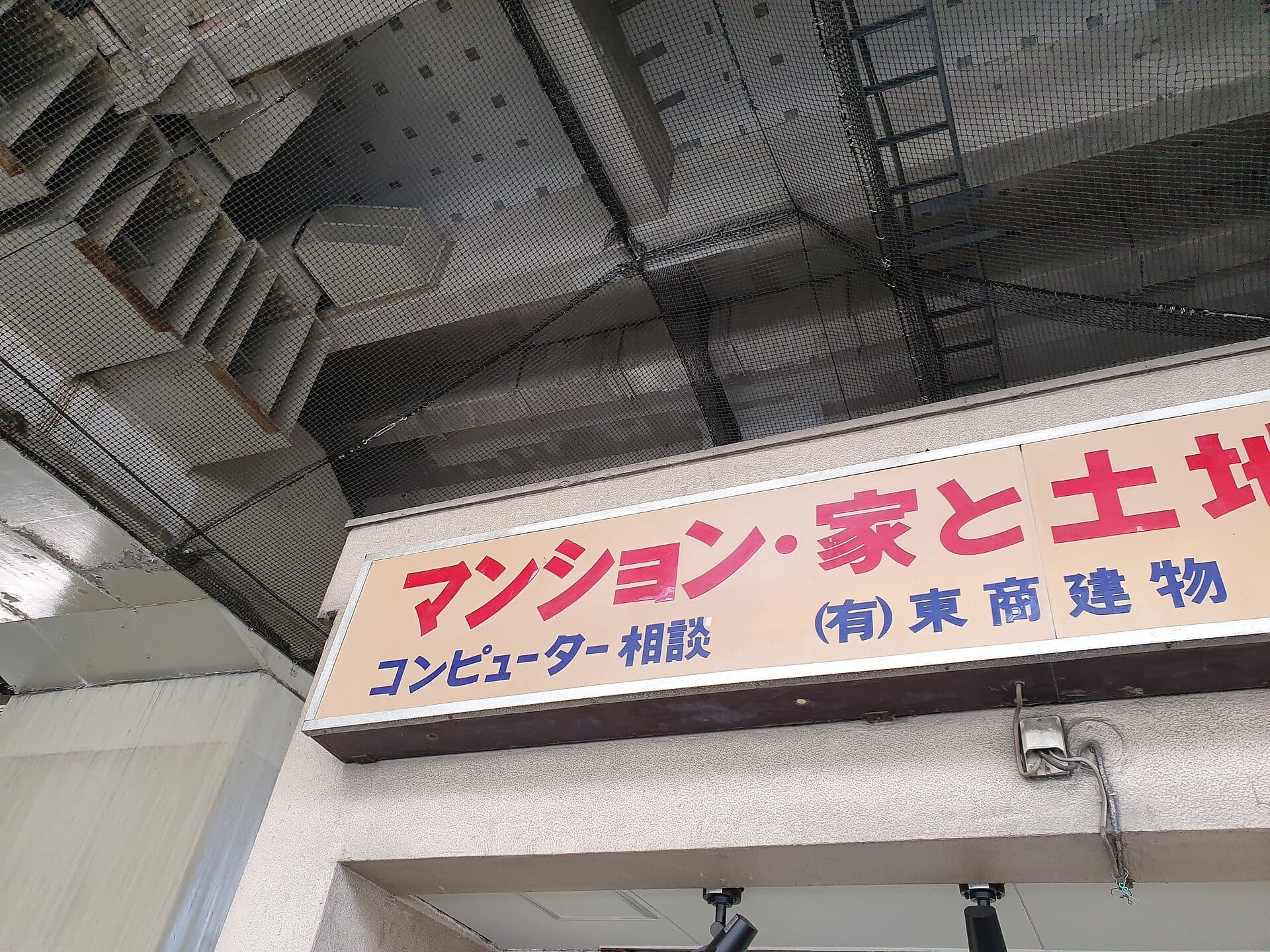 Enseigne d'une agence immobilière japonaise annonçant appartements, maisons et terrains.