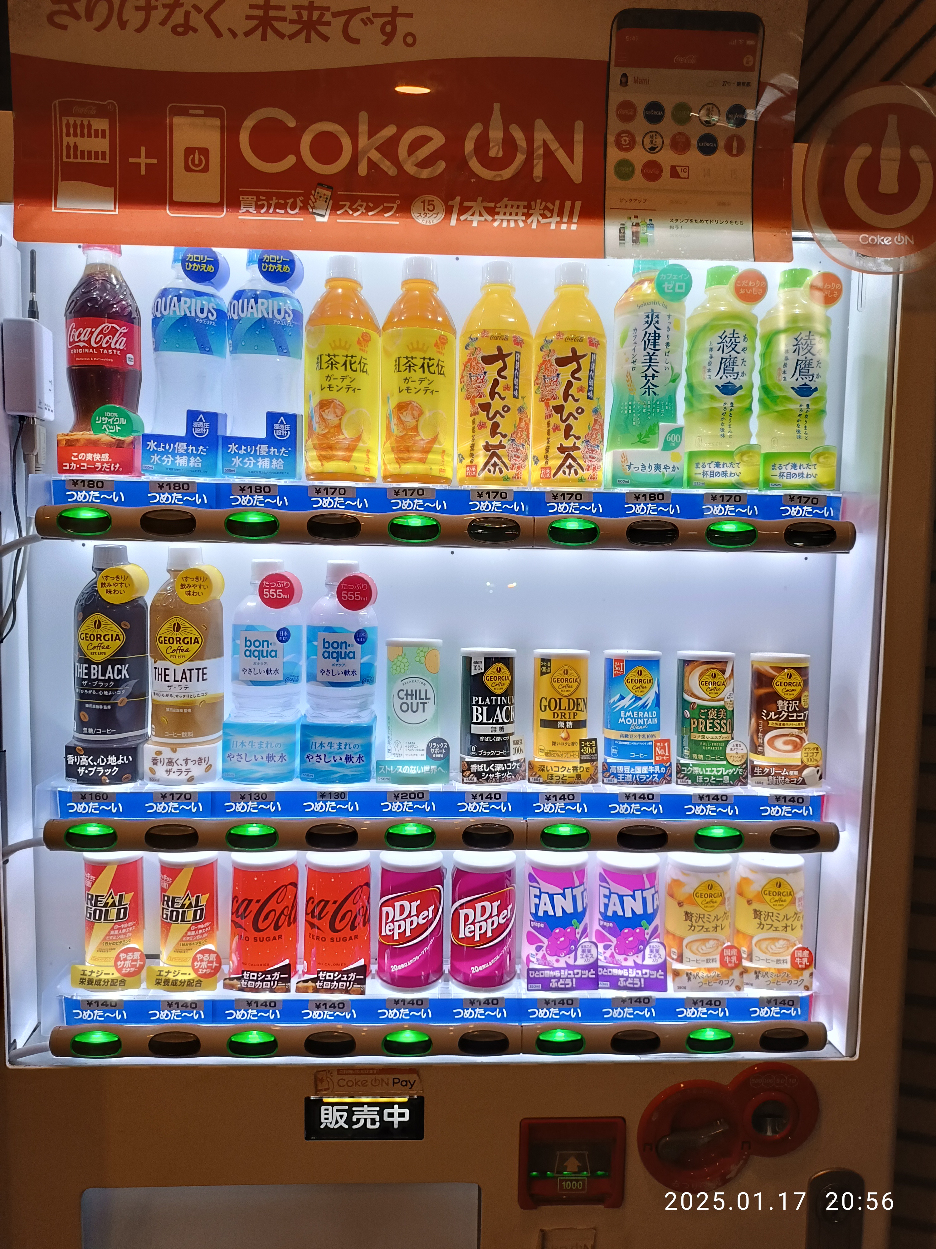 Row of illuminated vending machines along an Okinawa street at night, their bright fronts lighting up the empty sidewalk.