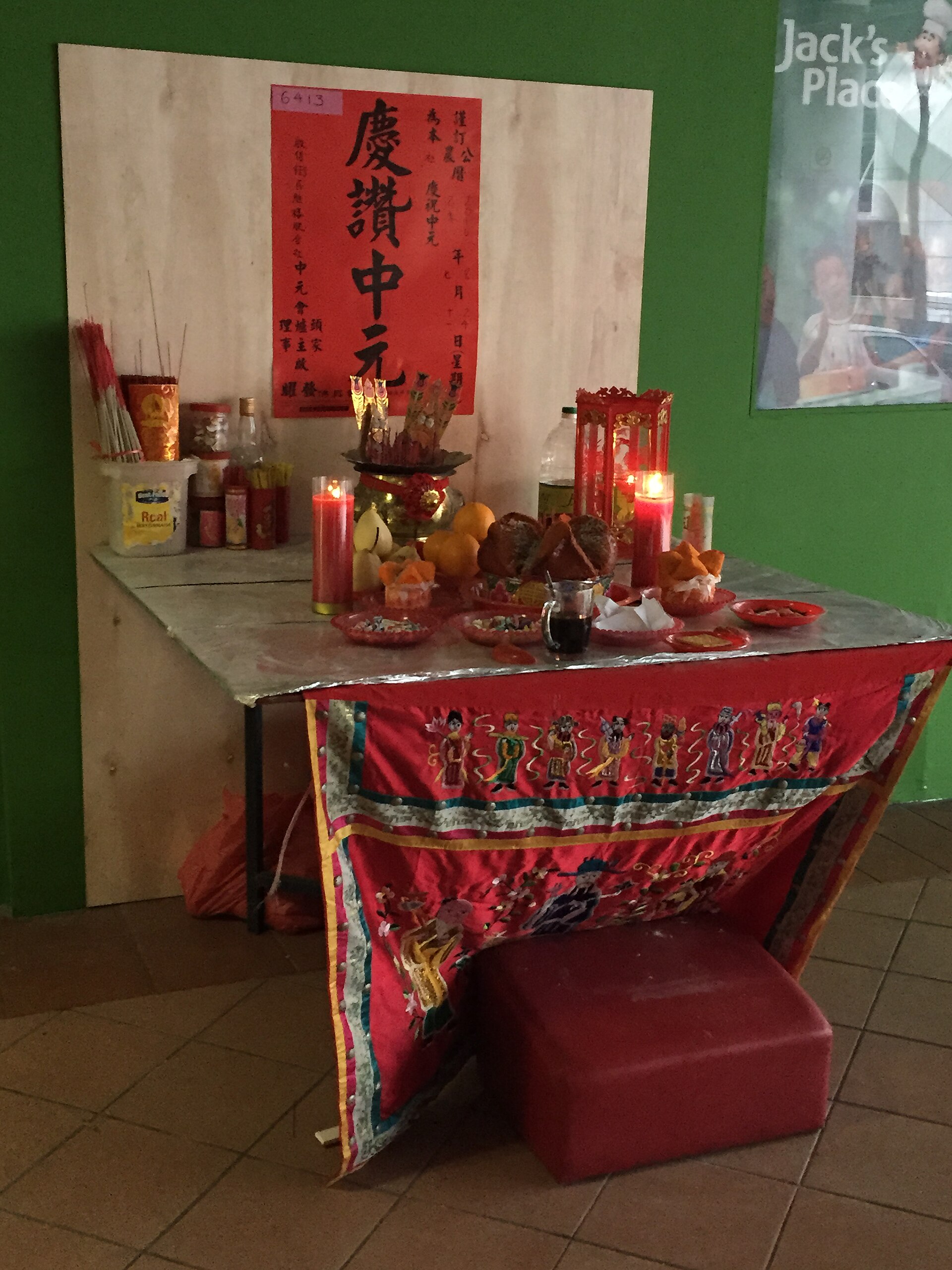 Autel d'offrandes du Zhongyuan dressé dans une rue : fruits, gâteaux, boissons et bâtons d'encens plantés dans un brûle-parfum