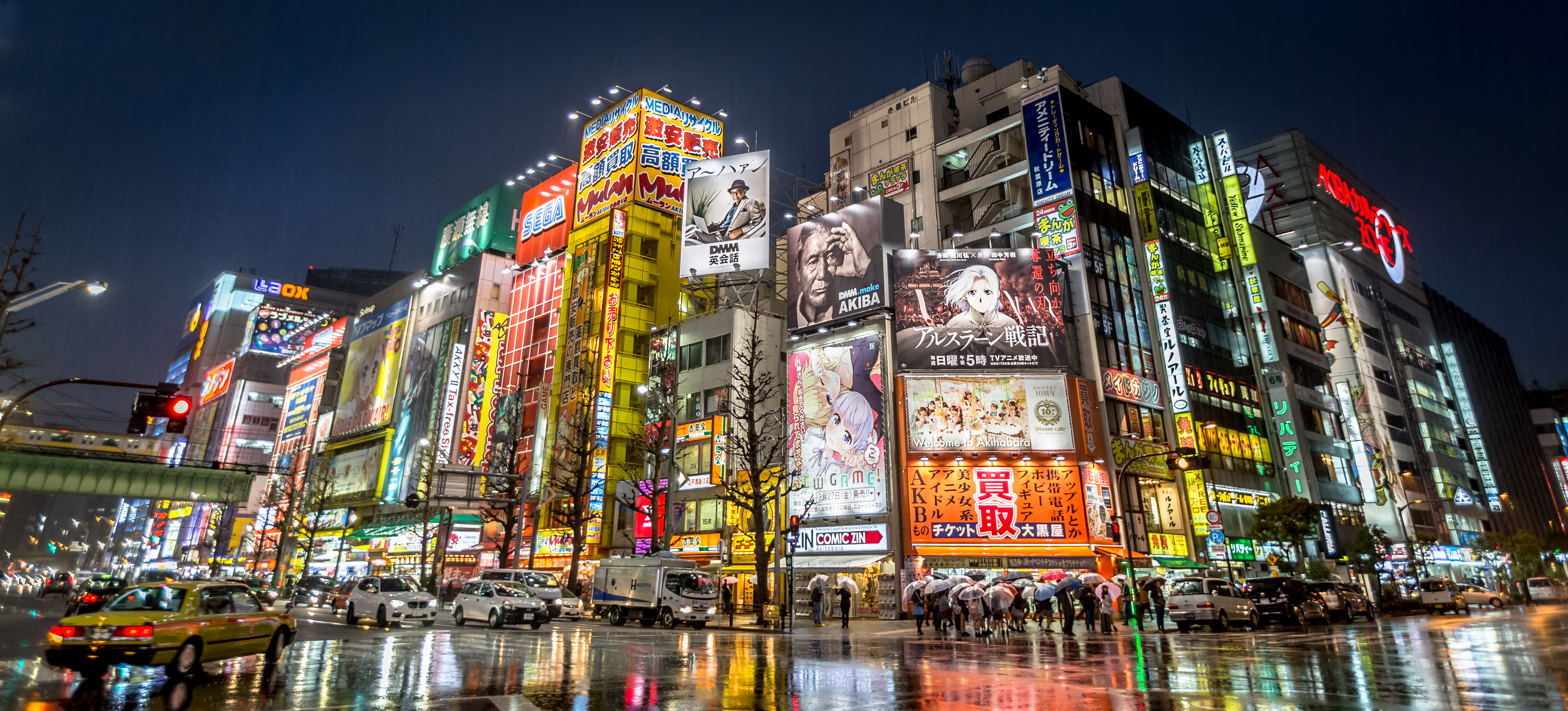 Illuminated Akihabara building façades at night, neon signs of otaku-culture shops