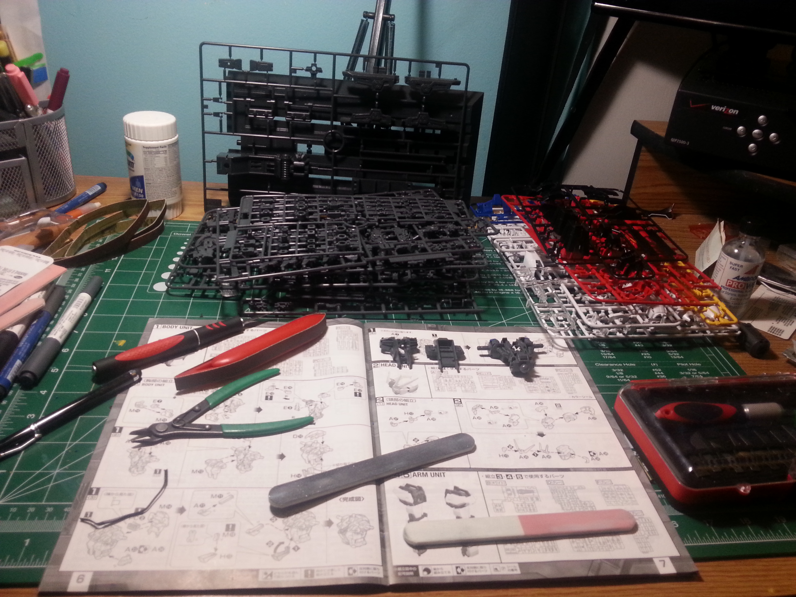 Mesa de trabajo de un modelista Gunpla con piezas y herramientas en pleno montaje, símbolo de la industria del modelismo nacida de Mobile Suit Gundam