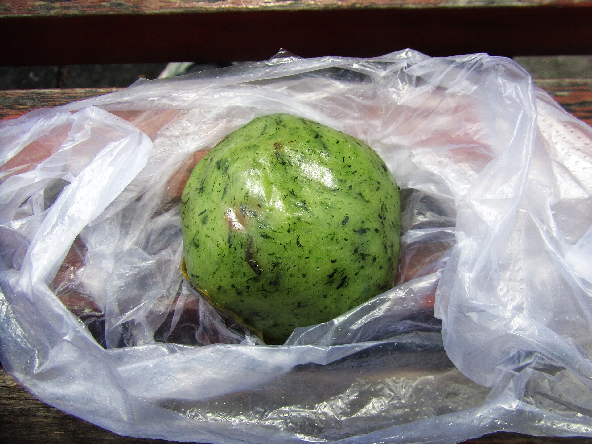 Qingtuan, jade-green glutinous rice balls colored with mugwort, presented in a bamboo basket