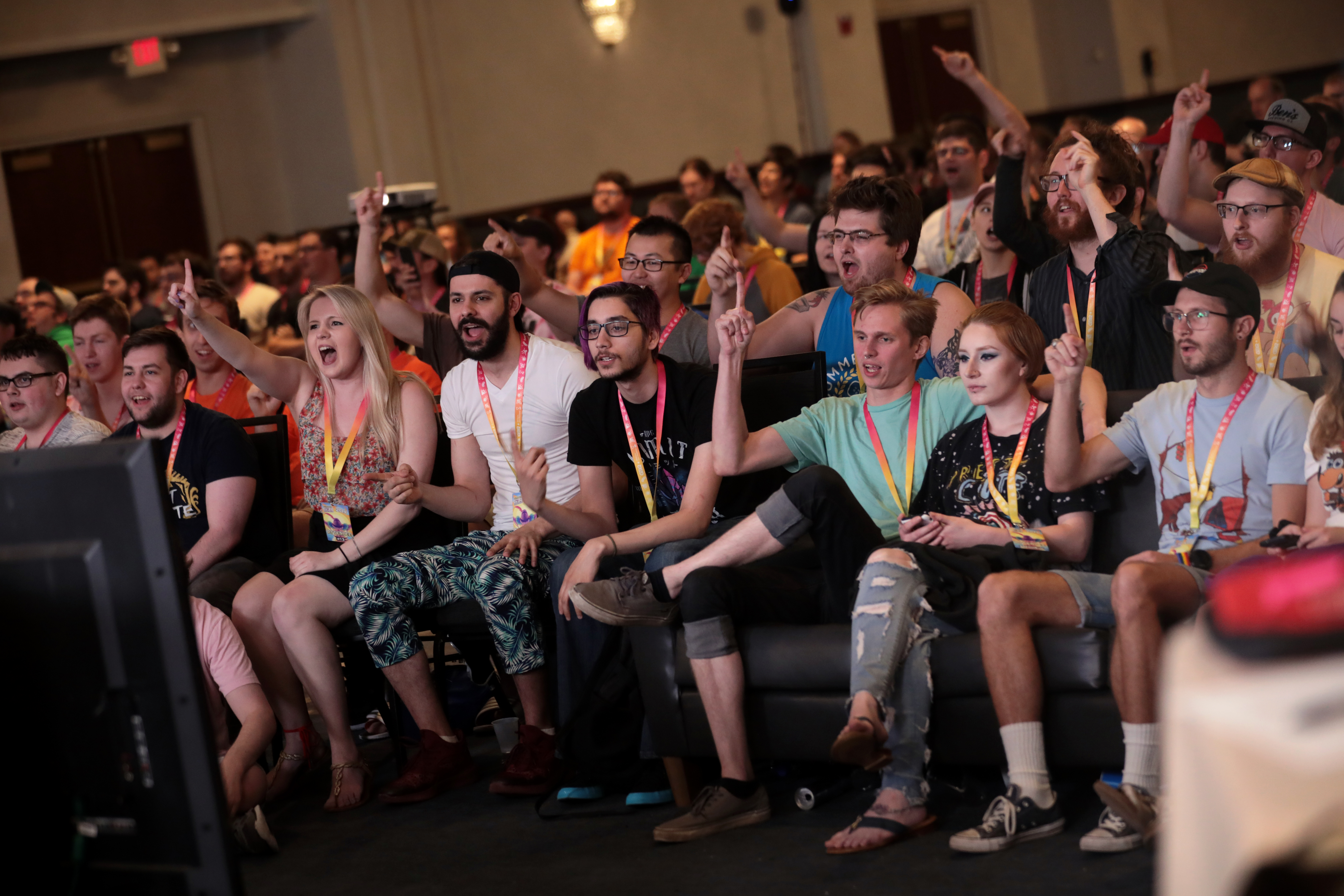 The audience of a charity speedrun marathon, seated on couches and cheering a run at Summer Games Done Quick.
