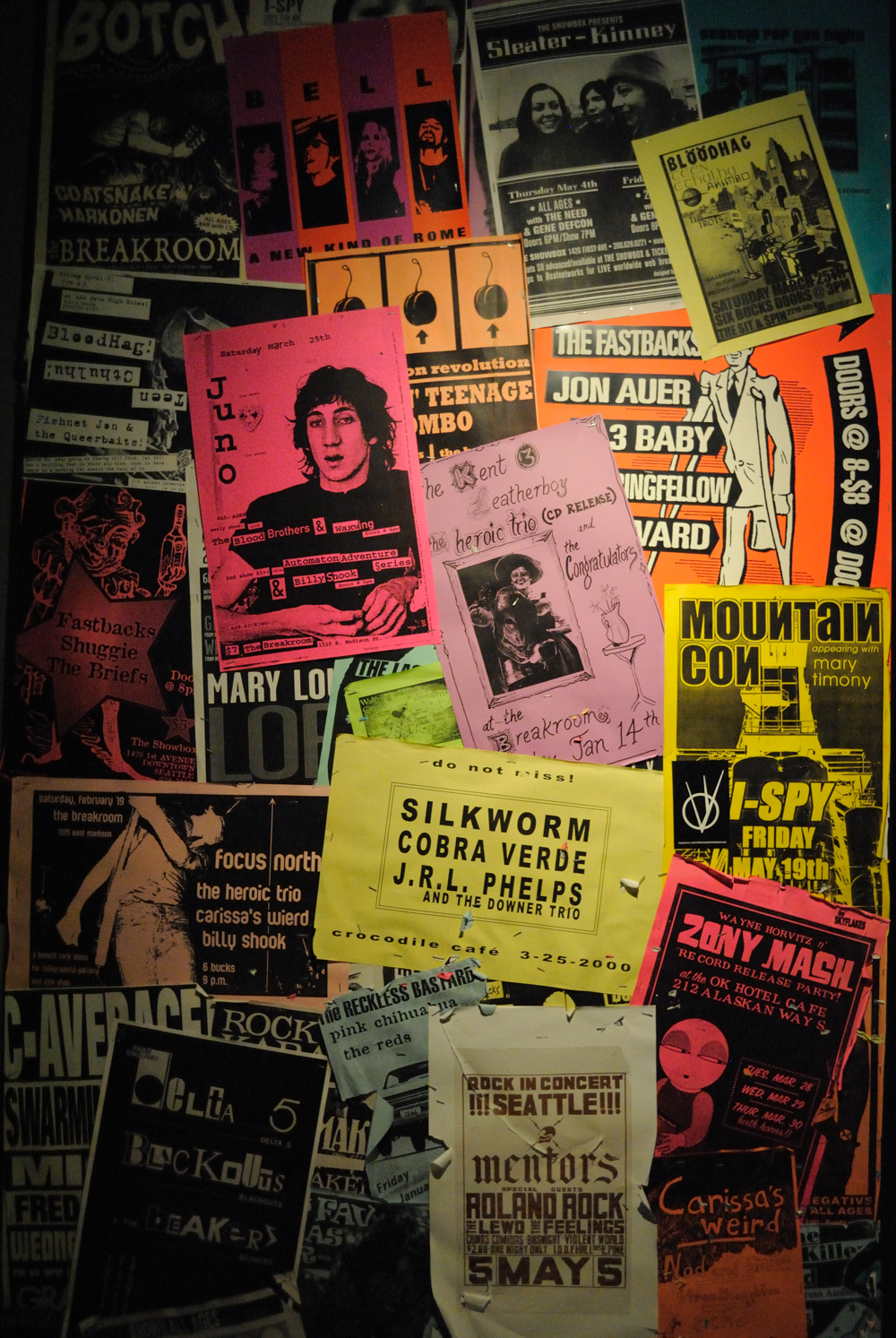 A wall covered in flyers and posters for rock band concerts