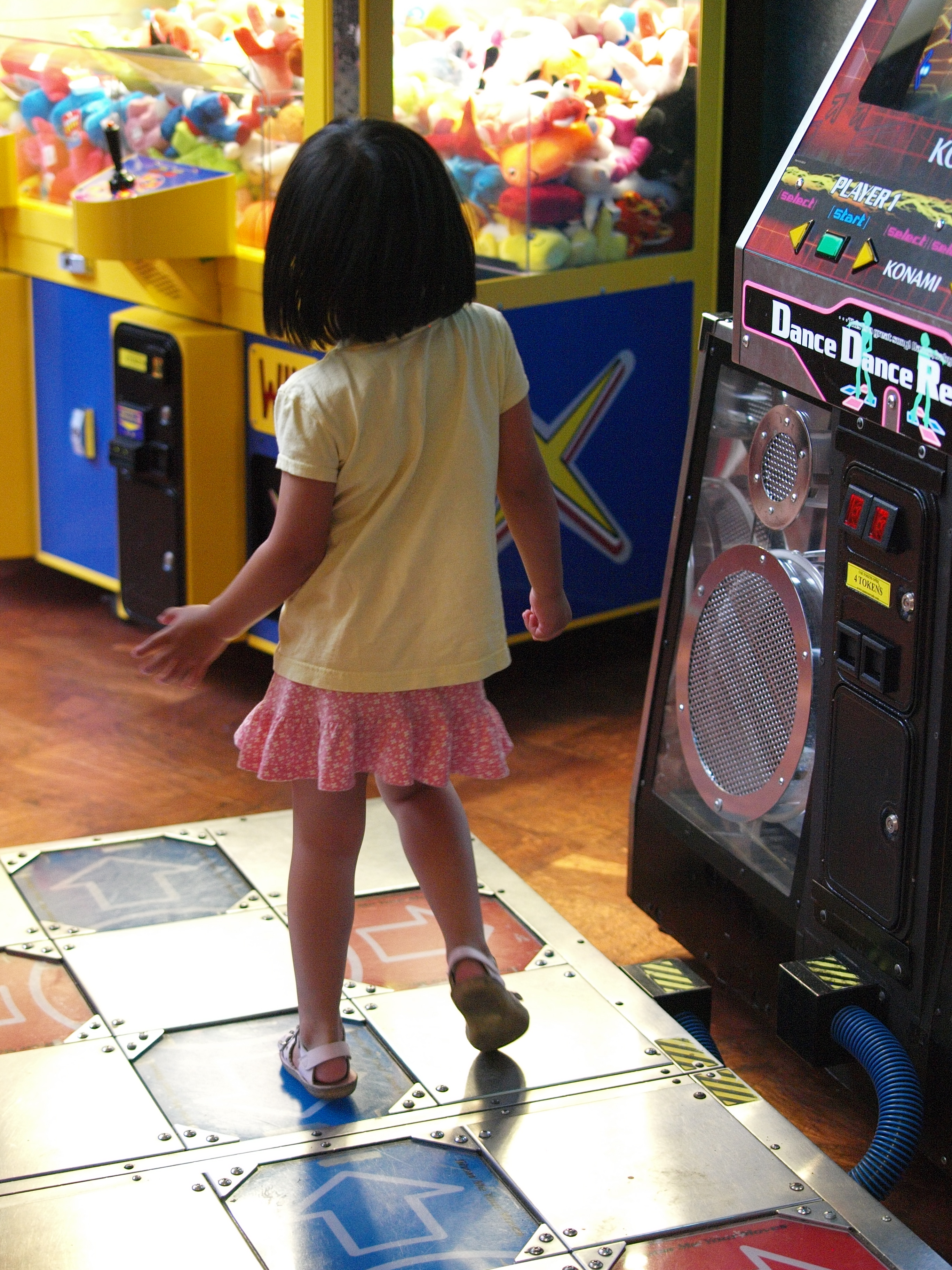 A player on a Dance Dance Revolution arcade cabinet with its sensor pad